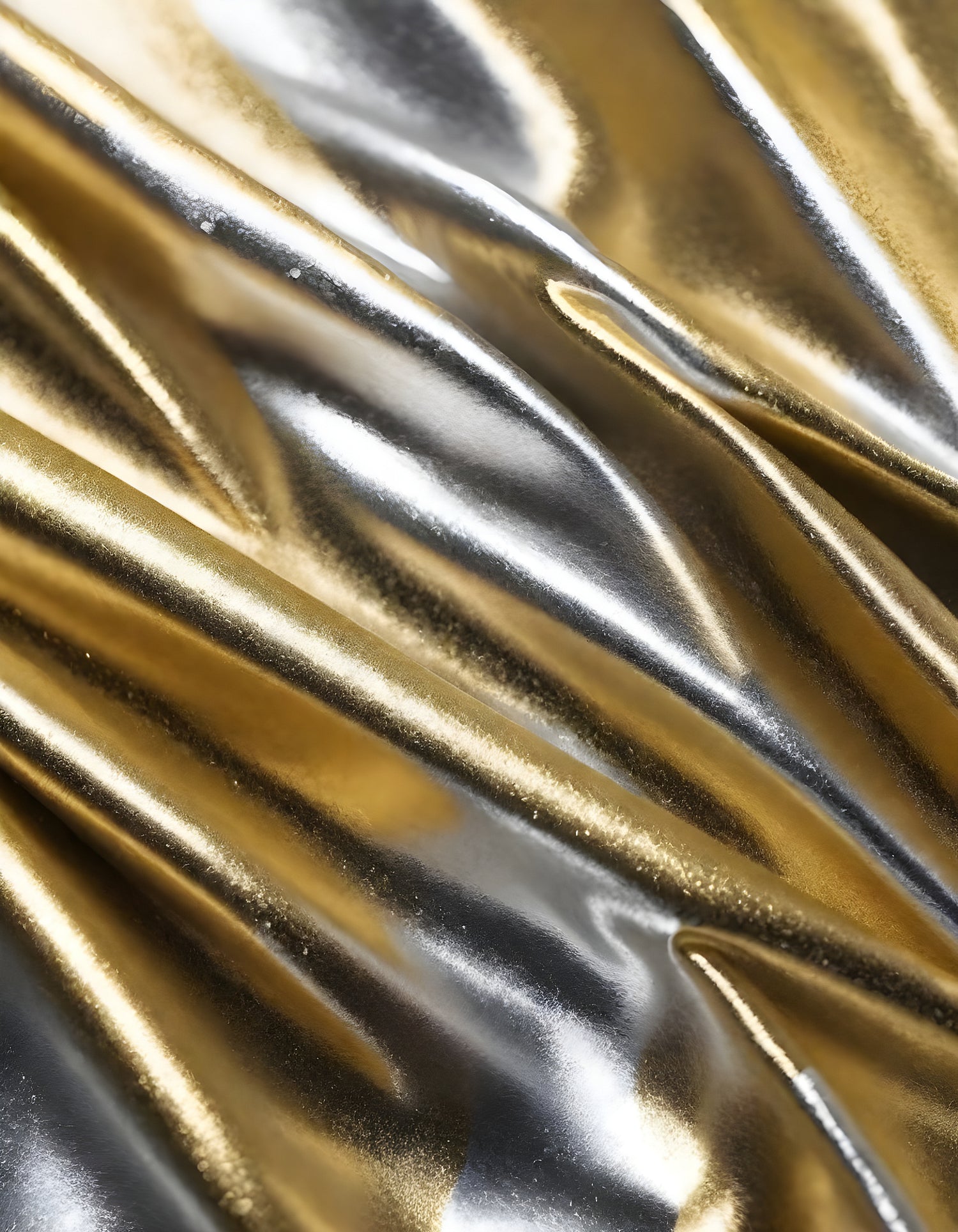 Metallic golden and silver fabric creates elegant textures with intricate folds and reflections under soft lighting