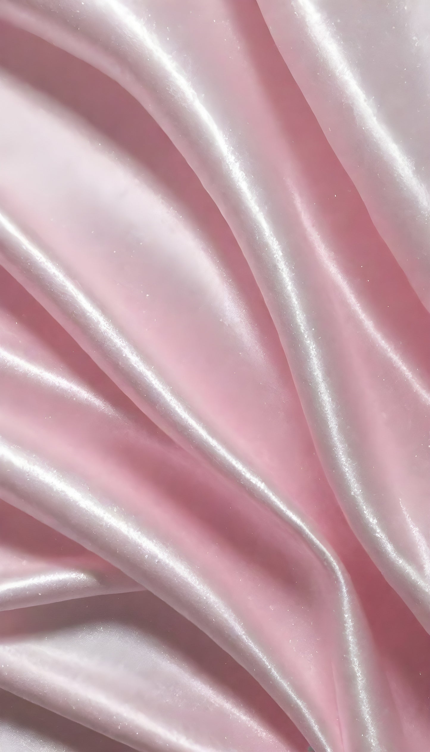 A close-up view of soft, shiny pink fabric draped elegantly, highlighting its smooth texture and sheen, perfect for luxurious designs