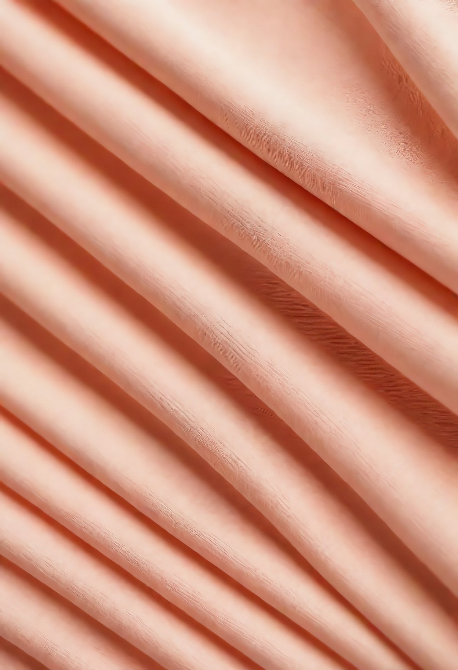 Soft peach satin fabric with elegant draping and subtle sheen