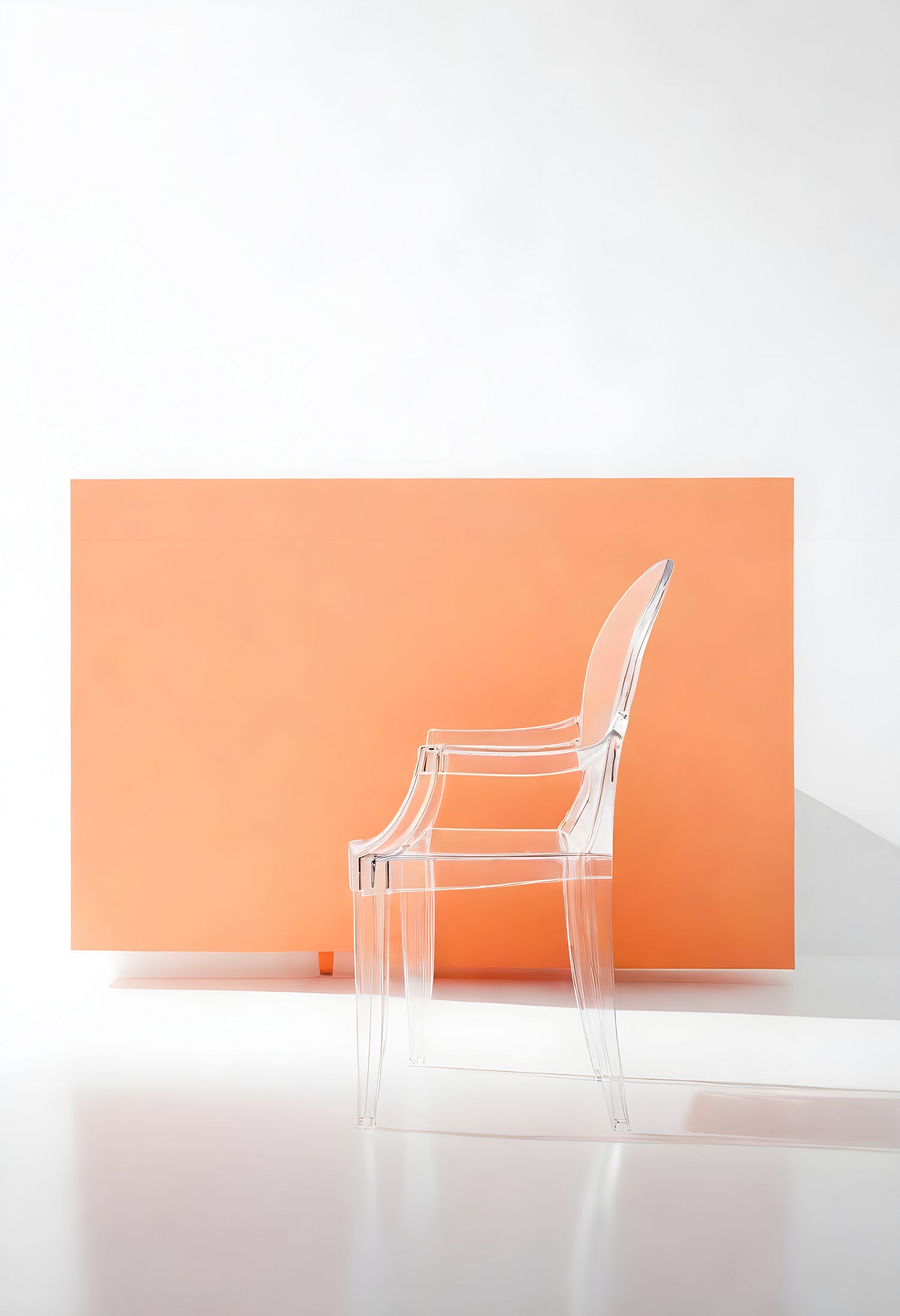 A clear acrylic chair stands against an orange backdrop in a bright, minimalist interior space during daylight hours