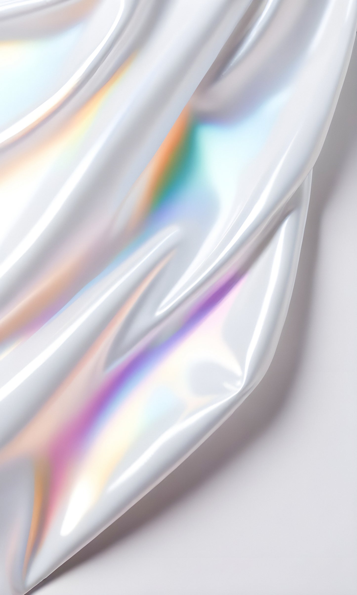 Abstract reflection on smooth, shimmering fabric with rainbow hues showcased on a light background